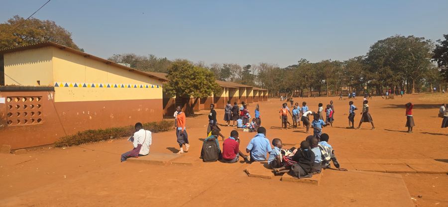 Learners at break time beside the painted classroom wall